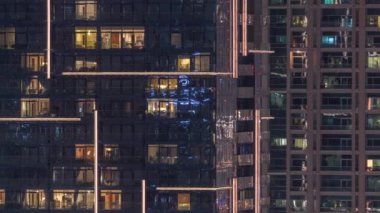 Geceleri apartmanda insanların oturduğu parlak pencereler..