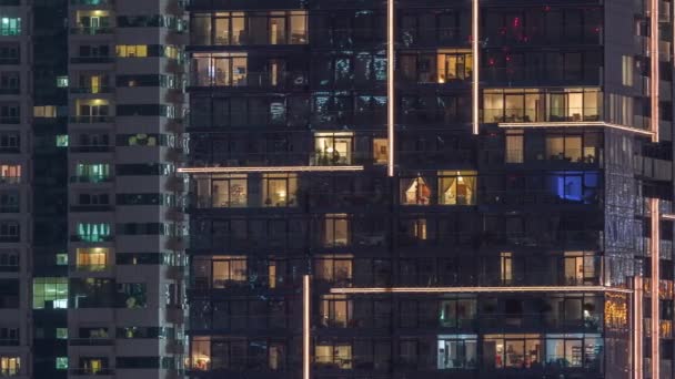 一排排明亮的窗户，晚上有很多人在公寓楼里. — 图库视频影像