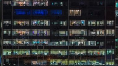 Modern ofis binası, gece vakti büyük pencereleri, pencereleri aydınlık.