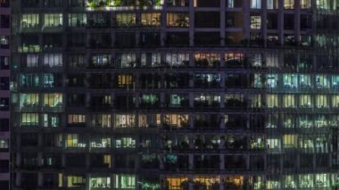 Modern ofis binası, gece vakti büyük pencereleri, pencereleri aydınlık.