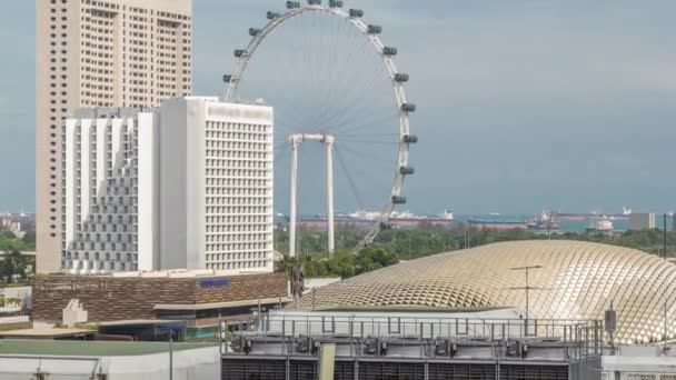 Сучасні будівлі в центрі Сінгапуру timelapse і гігантське колесо Ферріса видно на синьому тлі неба. — стокове відео