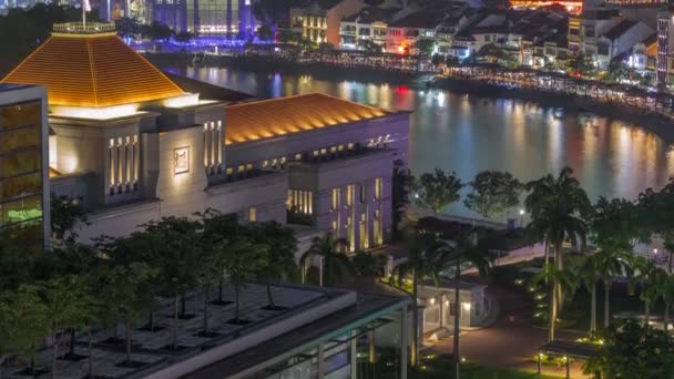 Parlament Ház Szingapúr belvárosában légi éjszakai időtöltés és csónak rakpart a háttérben. — Stock videók