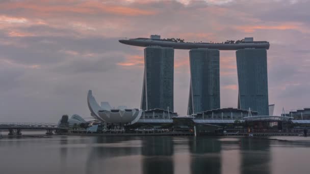 Ανατολή ηλίου κοντά Marina Bay Sands Hotel δεσπόζει στον ορίζοντα στο Marina Bay στη Σιγκαπούρη timelapse. — Αρχείο Βίντεο