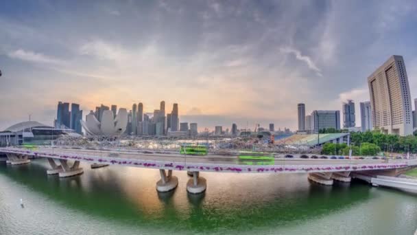 Légi kilátás naplementére a Helix hídon és a Bayfront Avenue-n, forgalmi idővel a Marina Bay-nél, Szingapúrban — Stock videók