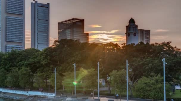 Ηλιοβασίλεμα στους ουρανοξύστες της Σιγκαπούρης με λευκή γέφυρα Άντερσον κοντά στο πάρκο Esplanade timelapse. — Αρχείο Βίντεο