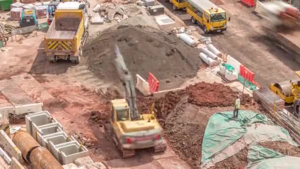 Şehirde iş yerinde ağır araç, kazıcı ve buldozer bulunan büyük bir inşaat sahası — Stok video