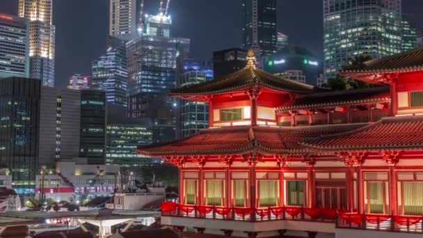 Buddha Tand Relic Temple vaknar till liv på natten timelapse i Singapore Chinatown, med staden skyline i bakgrunden. — Stockvideo