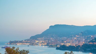 Monte Carlo 'nun şehir manzarası günden geceye geçiş zamanı, Monako yaz günbatımından sonra. Akşam sisi. Limandaki yatlar. Kaptan Martin 'den üst görünüm
