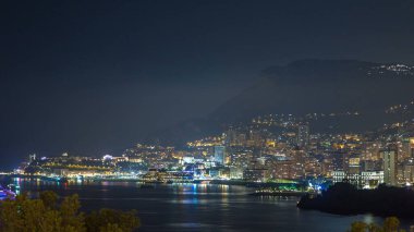 Monte Carlo 'nun şehir manzarası, Monaco, gece vakti. Akşam sisi ve gece aydınlanması. Limandaki yatlar. Kaptan Martin 'den üst görünüm