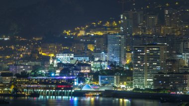 Monte Carlo 'nun şehir manzarası, Monaco, gece vakti. Akşam sisi ve binaların gece aydınlığı. Limandaki yatlar. Kaptan Martin 'den üst görünüm