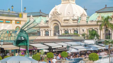 Kumarhane Meydanı. Monte Carlo 'da Casino zamanının yakınında bir kafe. İçerideki masada oturan insanlar. Güneşli yaz günü