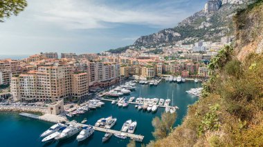 Fontvieille zaman diliminin panoramik görüntüsü - Monaco 'nun yeni bir bölgesi. Tekneler, limanda yatlar ve yüksek katlı bir apartman kompleksi. Monako Prensliği Fransız Rivierası 'nda bulunan bağımsız bir şehir devletidir.