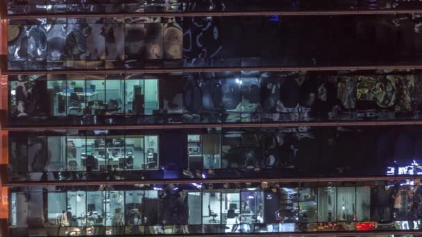 Büro-Wolkenkratzer außen am späten Abend mit eingeschaltetem Innenlicht und Menschen, die im Zeitraffer der Nacht arbeiten — Stockvideo