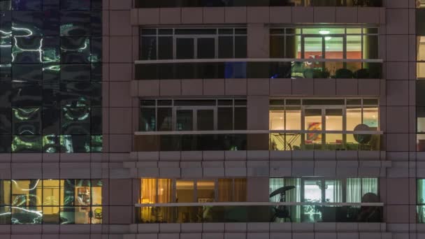 Vista nocturna del apartamento exterior timelapse edificio. Rascacielos de gran altura con luces intermitentes en las ventanas — Vídeos de Stock