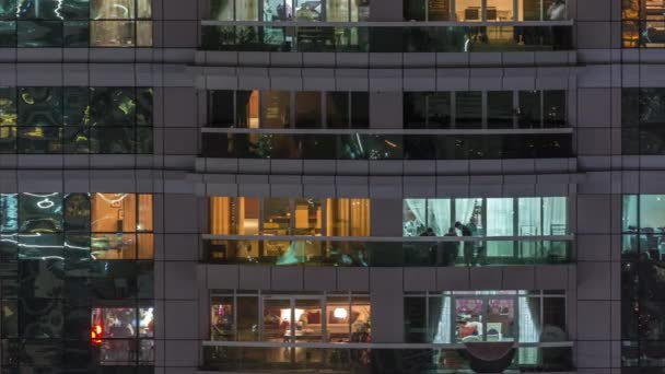 Vista nocturna del apartamento exterior timelapse edificio. Rascacielos de gran altura con luces intermitentes en las ventanas — Vídeos de Stock