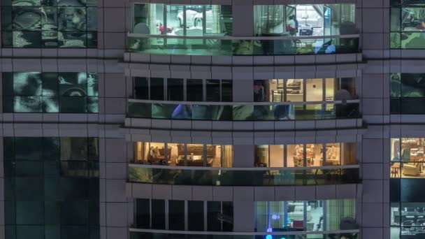 Vista nocturna del apartamento exterior timelapse edificio. Rascacielos de gran altura con luces intermitentes en las ventanas — Vídeos de Stock