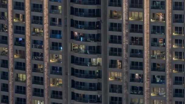 Vista nocturna del timelapse exterior de la torre del apartamento. Rascacielos de gran altura con luces intermitentes en las ventanas — Vídeo de stock