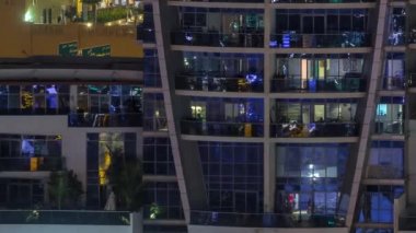 Geceleri apartmanda insanların oturduğu parlak pencereler..