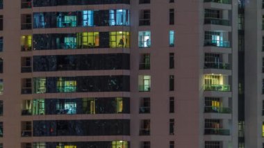Geceleri apartmanda insanların oturduğu parlak pencereler..