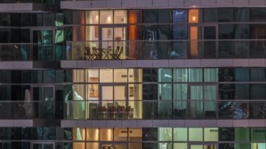 Geceleri apartmanda insanların oturduğu parlak pencereler..