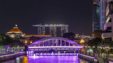 Singapur finans bölgesinin Skyline 'ı ve Elgin Köprüsü' nün arkasındaki Marina körfezi ve Singapur Nehri gece hipervanesi. Parlamento binası sol tarafta.