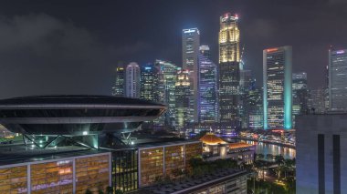 Singapur Merkez Ticaret Bölgesi 'nin rengarenk hava zaman çizelgesi yukarıdan Singapur Hukuk Akademisi ve Parlamento Binası' nın aydınlatıldığı Marina Körfezi 'ndeki şehir silueti