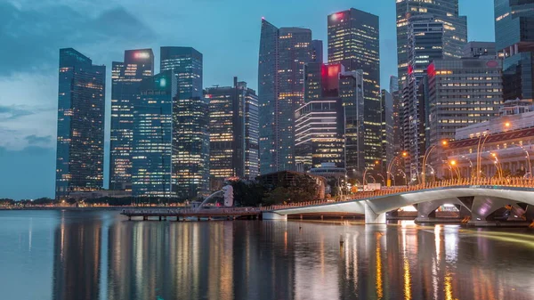 背景のエスプラネード橋とダウンタウンの中心部の高層ビルシンガポールの夜から昼への移行時間経過 水面に映るライトアップされた塔 — ストック写真