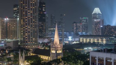St. Andrew Katedrali 'nin gece uçuşu. Singapur 'un en büyük katedrali olan Anglikan katedrali. Arkaplanda gökdelenler
