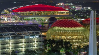 Singapur 'daki Marina Bay Sands rıhtımında güzel bir lazer ve müzik fıskiyesi gösterisi. Kordon tiyatrosu aydınlatılmış çatı. Etrafta yüzen tekneler