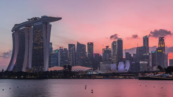 ガーデン イースト デイから夜の移行時間経過までの水の向こうから見たシンガポールのダウンタウンのスカイライン シンガポール ライトアップされた高層ビルが水面に映る — ストック写真