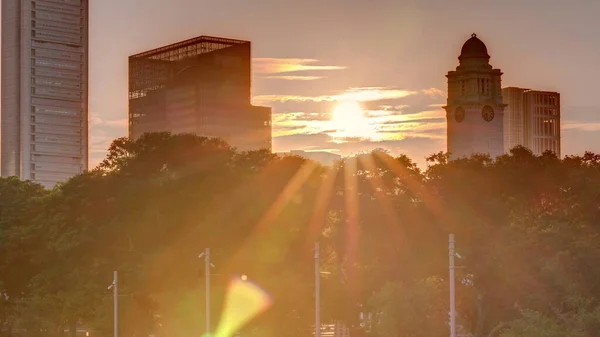 在新加坡摩天大楼的上空 夕阳西下 白色的安德森桥和几座金融区的塔楼映入眼帘 两边都有一些绿叶 — 图库照片