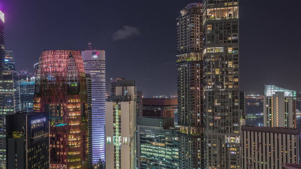 Aerial cityscape of Singapore downtown of modern architecture with illuminated skyscrapers night timelapse, view from above from skybridge viewpoint with glowing windows in towers