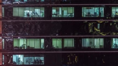 Ofis gökdelen dış gece geç saatlerde iç ışıklar ve gece timelapse içinde çalışan insanlar ile