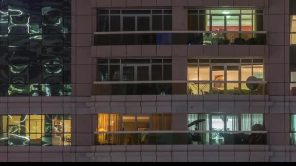 Vista nocturna del apartamento exterior timelapse edificio. Rascacielos de gran altura con luces intermitentes en las ventanas — Vídeos de Stock