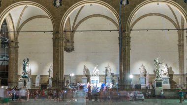 Piazza della Signoria Meydanı 'ndaki Loggia dei Lanzi' nin önündeki insanlar. Gece aydınlatması. FLORENCE, İTALYA
