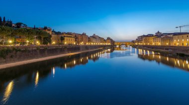 Arno Nehri ve Ponte Vecchio Köprüsü, gün batımından sonra İtalya 'nın Toskana, Floransa' daki Ponte alle Grazie kentinden günbegün geçiş zamanlarıdır. Akşamları nehire yansıyan yansıma