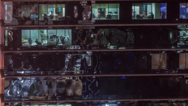 Gratte-ciel extérieur de bureau en fin de soirée avec lumières intérieures allumées et personnes travaillant à l'intérieur timelapse de nuit — Video