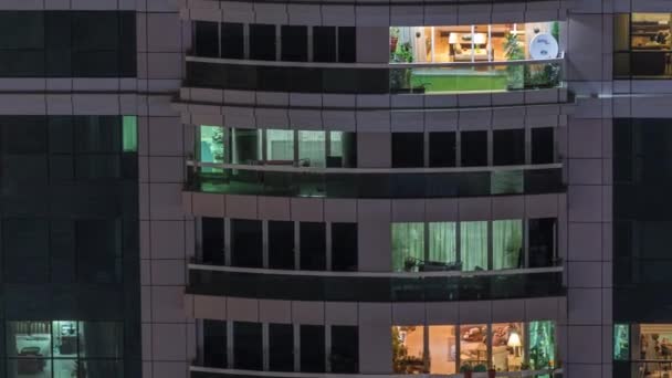 Vista nocturna del apartamento exterior timelapse edificio. Rascacielos de gran altura con luces intermitentes en las ventanas — Vídeos de Stock