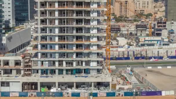 Vista aérea de un rascacielos en construcción con enormes grúas timelapse en Dubai . — Vídeos de Stock