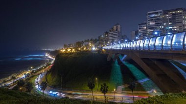 Villena Köprüsü 'nde trafik ve kısmi şehir manzarası var. Arka planda gece hızlandırılmış hız, Lima, Peru. Aydınlatılmış kıyı şeridi ve aşk parkı olan hava manzarası