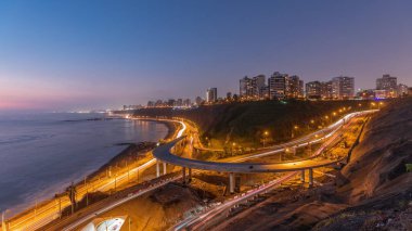 Lima 'nın sahil şeridinin havadan panoramik görüntüsü. Miraflores civarındaki gece gündüz geçiş zamanı, Lima, Peru. Husares De Junin rıhtımından okyanusla kesişen yol ve sahil trafiği