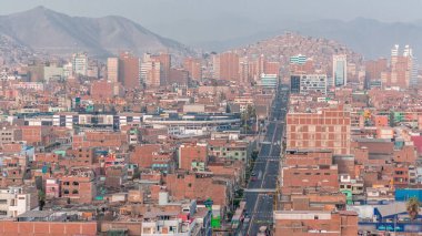 Lima şehrinin panoramik ufuk çizgisi yukarıdan birçok binanın havadan zamanlaması var. Arka planda tepeler olan fakir evler. Sokakta trafik vardı. Lima, Peru