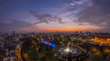 Havadan Park of the Reserve 'e en büyük şelale kompleksi olan sihirli su devresi ile geçiş zamanı. Yeşil çimenler ve ağaçlar. Arkaplanda şehir silüeti