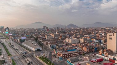 Via Expresa otoyolu ve Peru Ulusal Stadyumu yakınlarındaki trafikli metropol panoramik manzarası. Evler ve şehrin arka planında dağlar olan silueti. Lima, Peru