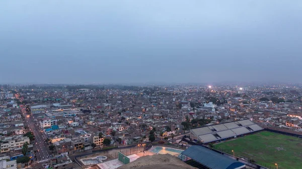 利马市的全景天际线从高处俯瞰 许多建筑物从小到大夜以继日地从山上经过 贫穷的房子 背景上有小山 街上的交通 秘鲁利马 — 图库照片