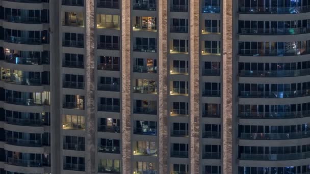 Vue de nuit de la tour d'appartement extérieur timelapse. gratte-ciel de grande hauteur avec des lumières clignotantes dans les fenêtres — Video