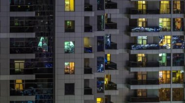 Geceleri apartmanda insanların oturduğu parlak pencereler..