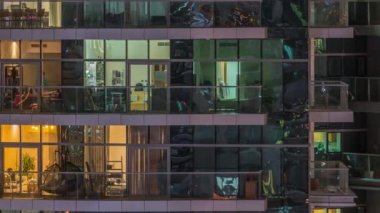 Geceleri apartmanda insanların oturduğu parlak pencereler..