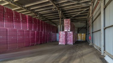 lojistik, depolama, sevkiyat, endüstri ve üretim konsepti zaman aşımı - iş yerindeki forklift yükleyicisi kargo kutularını depoya taşıyor