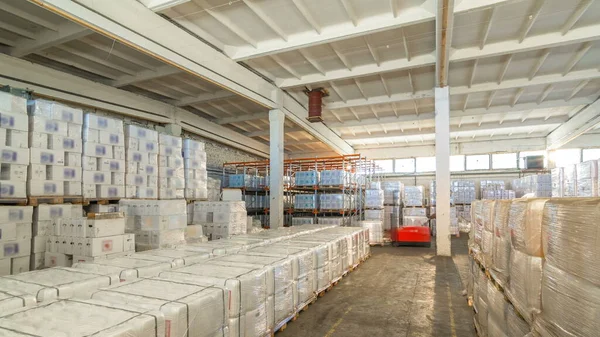 lojistik, depolama, sevkiyat, endüstri ve üretim konsepti zaman aşımı - iş yerindeki forklift yükleyicisi kargo kutularını depoya taşıyor